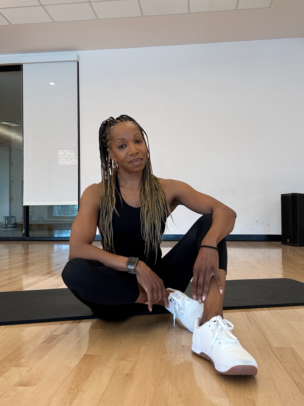 Tracie VanHook, founder of Fit To The Core Personal Training, seated in a gym.
